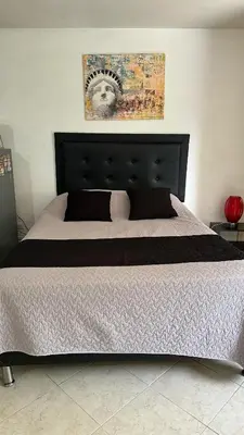 a bed with a black headboard in a bedroom at Apartaestudio Cerca a los Molinos in Medellín