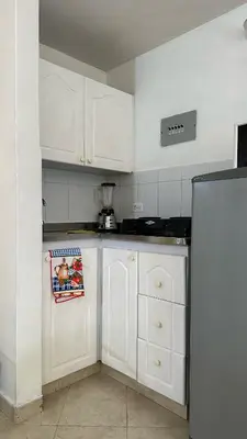 a kitchen with white cabinets and a refrigerator at Apartaestudio Cerca a los Molinos in Medellín