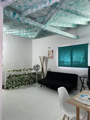 a living room with a black couch and a green wall at Excelente apartamento Envigado - Full Equipamento. in Envigado