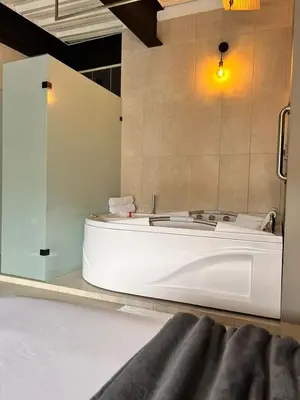 a bath tub in a bathroom with a glass wall at Seven hotel in Santa Fe de Antioquia