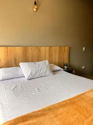 a bedroom with a white bed with a wooden headboard at Seven hotel in Santa Fe de Antioquia