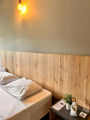 a bedroom with a bed with a wooden headboard and a table at Seven hotel in Santa Fe de Antioquia