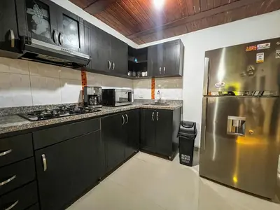a kitchen with black cabinets and a stainless steel refrigerator at Cerca a provenza. Amplio. Con todo cerca 273 DG in Medellín