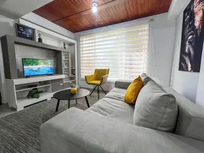 a living room with a gray couch and a television at Cerca a provenza. Amplio. Con todo cerca 273 DG in Medellín
