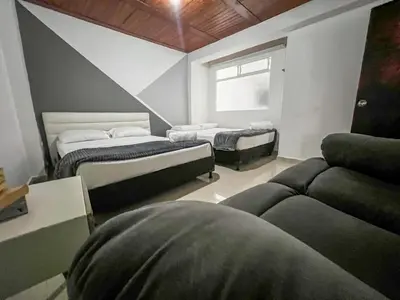 a room with two beds and a couch and a window at Cerca a provenza. Amplio. Con todo cerca 273 DG in Medellín