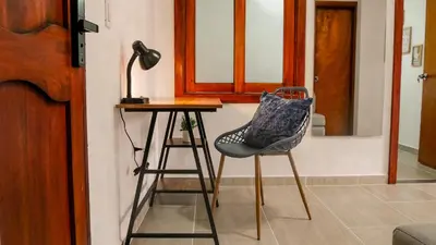 a chair sitting next to a table with a lamp at OCASSO JARDIN APARTAMENTO AZULEJO in Jardin