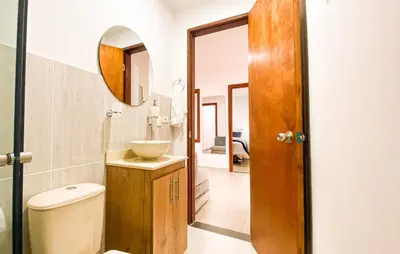 a bathroom with a toilet and a sink and a mirror at OCASSO JARDIN APARTAMENTO AZULEJO in Jardin