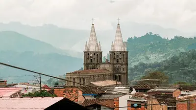 two towers of a church in a city with mountains in the background at OCASSO JARDIN APARTAMENTO AZULEJO in Jardin
