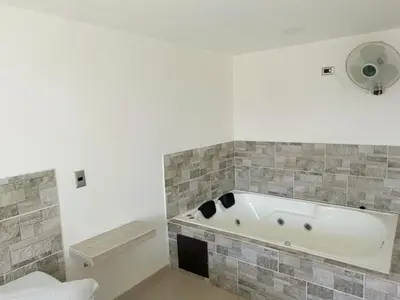 a bathroom with a bath tub in a room at Hotel Buenos Aires Central in Medellín