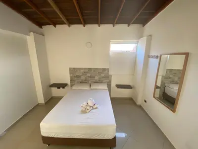 a small bedroom with a bed with a mirror and a mirror at Hotel Buenos Aires Central in Medellín