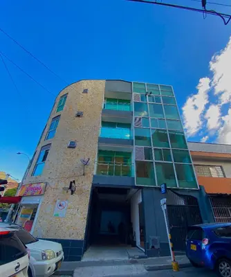 a tall brick building with windows on a street at Hotel Buenos Aires Central in Medellín