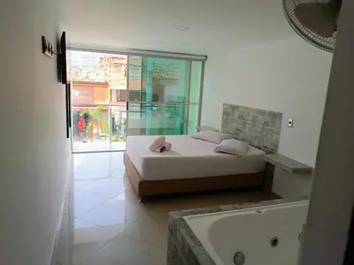 a bedroom with a bed and a bath tub at Hotel Buenos Aires Central in Medellín
