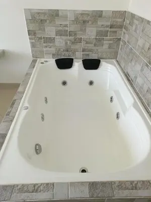 a white bath tub with two black bowls in it at Hotel Buenos Aires Central in Medellín