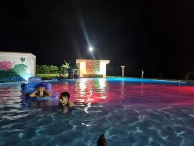 a couple of people in a swimming pool at night at Hotel nelumbo in Mariquita
