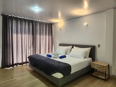 a bedroom with a bed and a large window at Hotel nelumbo in Mariquita