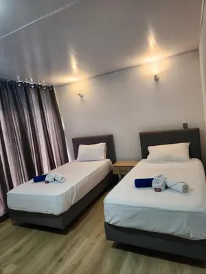 two beds in a hotel room with two at Hotel nelumbo in Mariquita