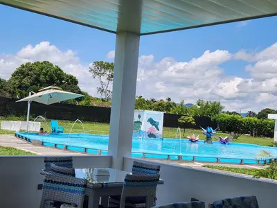 a view of a swimming pool from the porch of a house at Hotel nelumbo in Mariquita