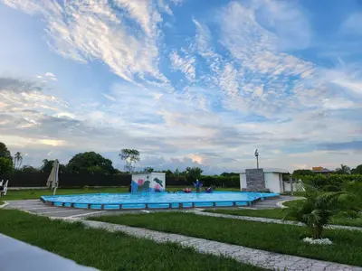 a large swimming pool under a cloudy sky at Hotel nelumbo in Mariquita