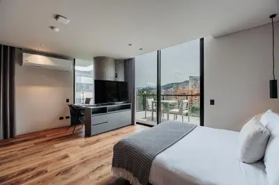a bedroom with a bed and a desk with a television at Kiin Living- 