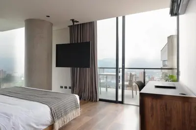 a bedroom with a bed and a desk and a large window at Kiin Living- 
