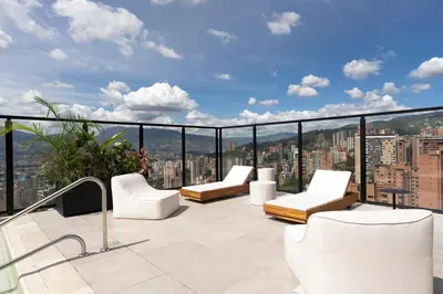 a balcony with white chairs and a view of a city at Kiin Living- 