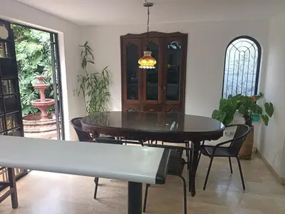 a dining room with a table and chairs and a window at Casa Campestre con terraza para 10 Poblado S Lucas 108 in Medellín