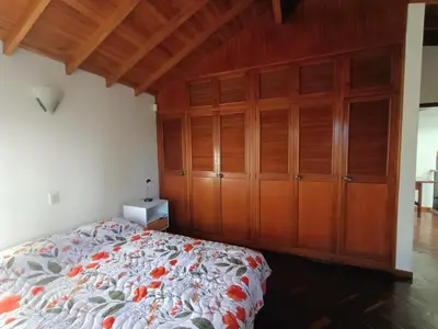 a bedroom with a bed and wooden cabinets at Casa Campestre con terraza para 10 Poblado S Lucas 108 in Medellín