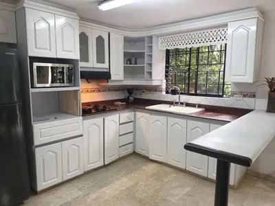a kitchen with white cabinets and a sink and a window at Casa Campestre con terraza para 10 Poblado S Lucas 108 in Medellín