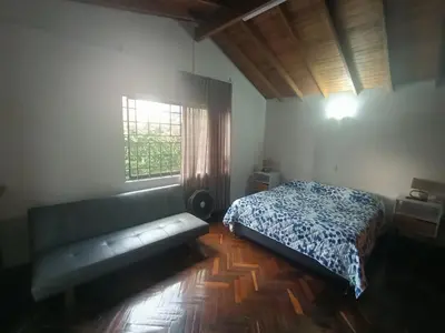 a bedroom with a bed and a couch and a window at Casa Campestre con terraza para 10 Poblado S Lucas 108 in Medellín