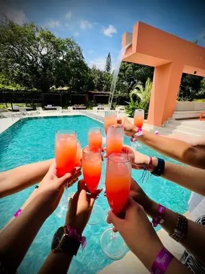 a group of people holding up drinks in front of a pool at Del Trópico Hotel By GyC Hotels in Sopetran