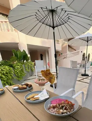 a table with plates of food and an umbrella at Del Trópico Hotel By GyC Hotels in Sopetran