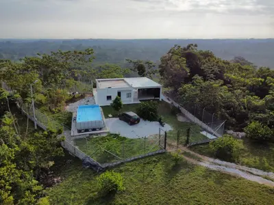 an overhead view of a house with a car parked in front at Cabaña Campestre con Piscina en la Hacienda Nápoles in Doradal