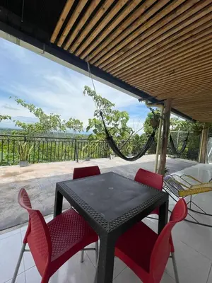 a black table and chairs on a patio with a hammock at Cabaña Campestre con Piscina en la Hacienda Nápoles in Doradal