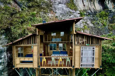 a tree house with a balcony and tables and chairs at LA CASA EN EL AIRE - Abejorral in Abejorral