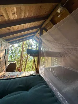 a hammock in a tree house with a window at LA CASA EN EL AIRE - Abejorral in Abejorral