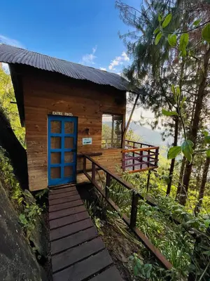 a small cabin with a blue door on a wooden ramp at LA CASA EN EL AIRE - Abejorral in Abejorral