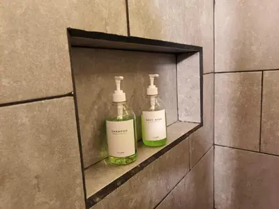 two bottles of soap sitting on a wall in a bathroom at Hospedaje Oasis Blue Laureles Medellín in Medellín