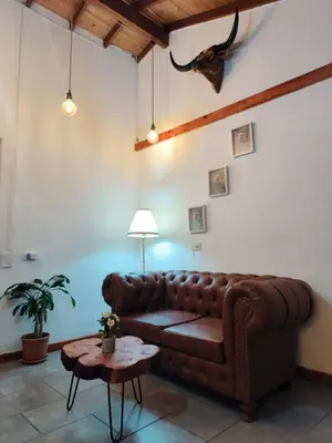 a living room with a brown leather couch and a table at Hospedaje Oasis Blue Laureles Medellín in Medellín