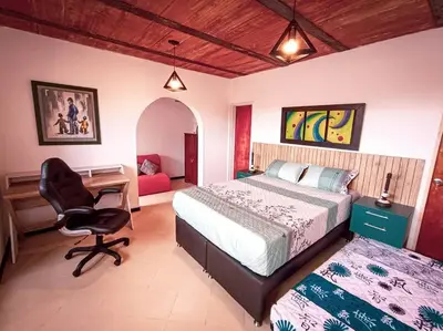 a bedroom with a bed and a desk and a chair at Amplio duplex con terraza privada. in Medellín