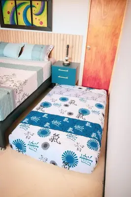 a small bedroom with two beds and a table at Amplio duplex con terraza privada. in Medellín