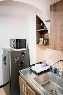 a kitchen with a stainless steel refrigerator and a sink at Amplio duplex con terraza privada. in Medellín