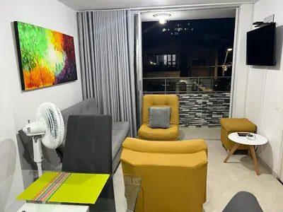 a living room with two chairs and a fan at AMOBLADO LOS MOLINOS in Medellín