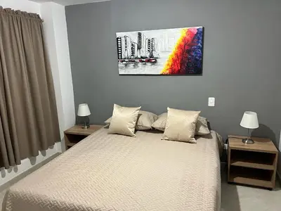 a bedroom with a bed and a painting on the wall at AMOBLADO LOS MOLINOS in Medellín