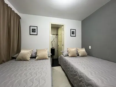 two beds in a room with white walls at AMOBLADO LOS MOLINOS in Medellín