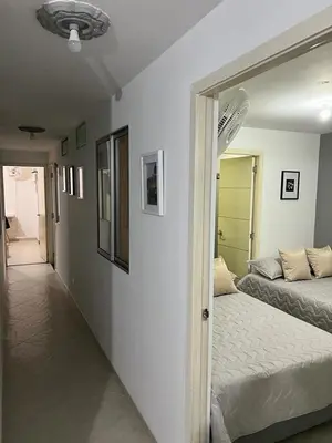 a bedroom with two beds and a hallway with a mirror at AMOBLADO LOS MOLINOS in Medellín