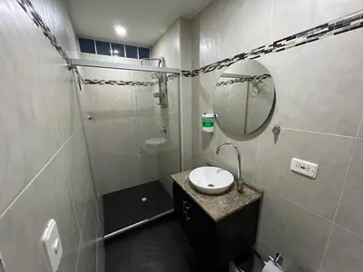 a bathroom with a sink and a shower with a mirror at AMOBLADO LOS MOLINOS in Medellín