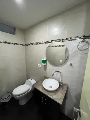 a bathroom with a toilet and a sink and a mirror at AMOBLADO LOS MOLINOS in Medellín