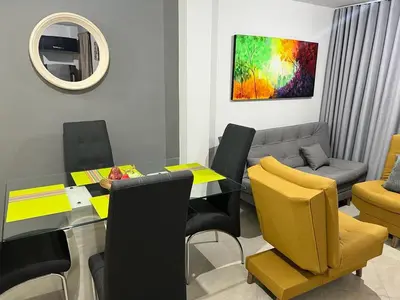 a living room with a table and chairs and a couch at AMOBLADO LOS MOLINOS in Medellín