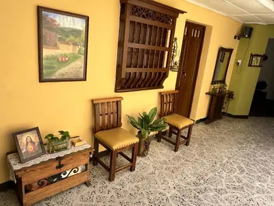 a living room with two chairs and a table at Casa Grande Hostal in Medellín