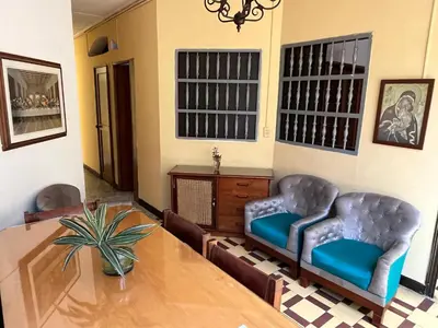 a dining room with two chairs and a table at Casa Grande Hostal in Medellín